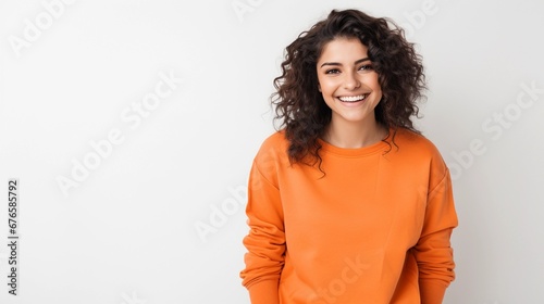 Brunette in orange sweatshirt on white background, smiling woman showing positive emotions
