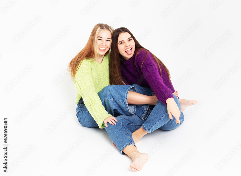 Two fashion laughing female friends hugging and having fun Two fashion laughing female friends hugging and having fun