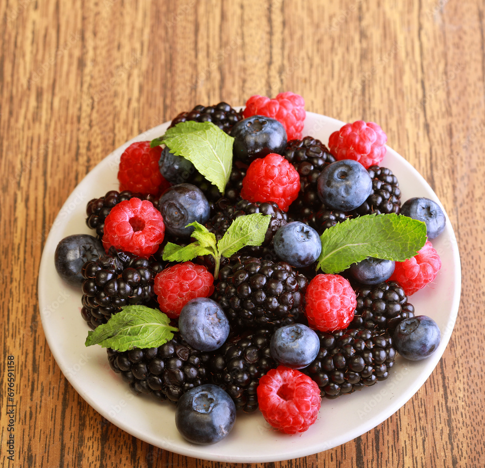 Raspberries, blackberries and blueberries in white bowl. Raspberries, blackberries and blueberries in white bowl.