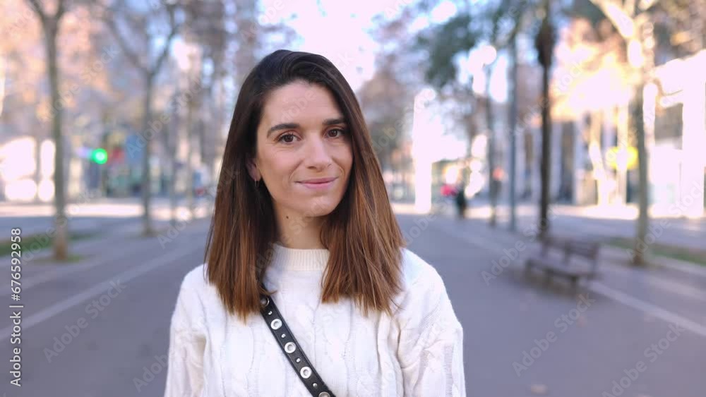 Face portrait of joyful young pretty woman standing at city street. Happy caucasian female smiling at camera over urban background. High quality 4k footage Face portrait of joyful young pretty woman standing at city street. Happy caucasian female smiling at camera over urban background. High quality 4k footage
