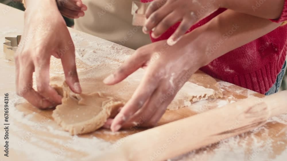 Caring African American mother making cookie with her little daughter in kitchen at home. Cute obedient kid helping her lovely mom. Cooking tasty bakery for Christmas celebration. Concept of baking. Caring African American mother making cookie with her little daughter in kitchen at home. Cute obedient kid helping her lovely mom. Cooking tasty bakery for Christmas celebration. Concept of baking.