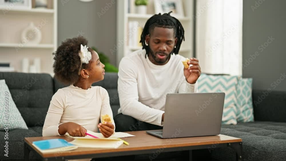 African american father and daughter eating croissant drawing and working high five at home