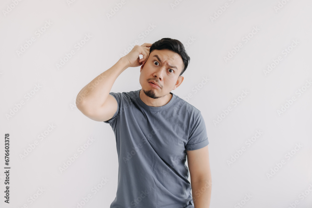 Confused face of asian man in blue t-shirt stand isolated on white. Confused face of asian man in blue t-shirt stand isolated on white.
