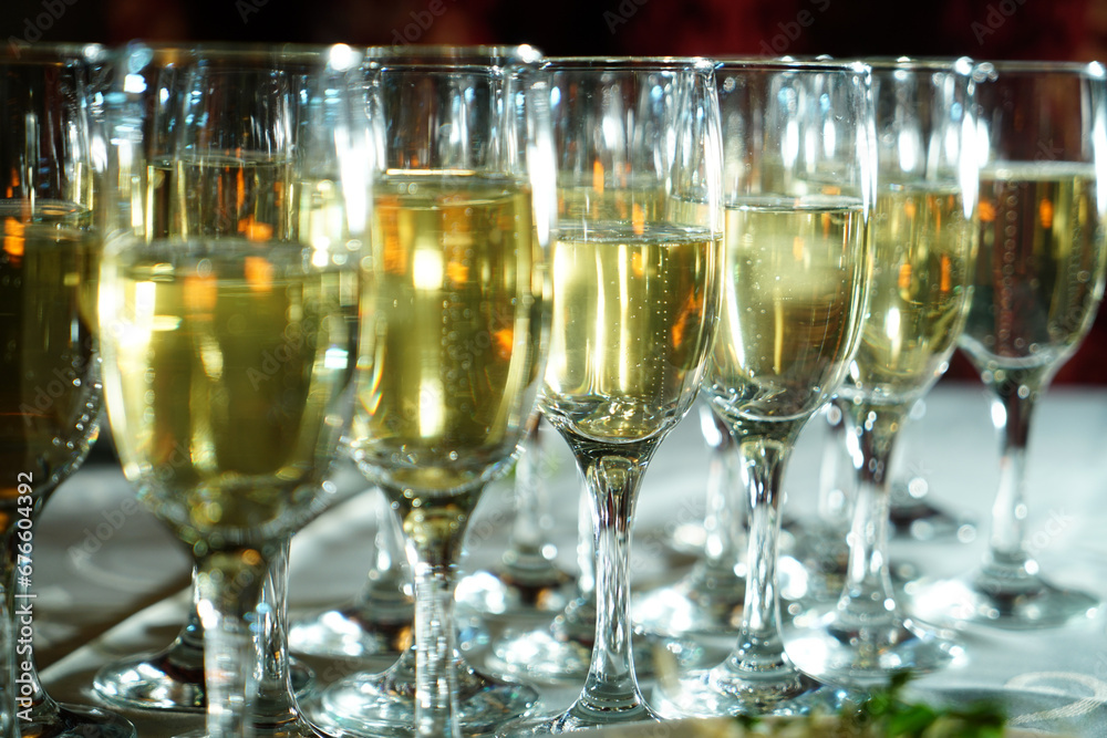 a stylishly set table with a glass of champagne. A charming glass filled with sparkling drink shines in the light. The table is covered with an elegant tablecloth a stylishly set table with a glass of champagne. A charming glass filled with sparkling drink shines in the light. The table is covered with an elegant tablecloth