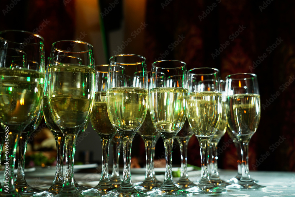 a stylishly set table with a glass of champagne. A charming glass filled with sparkling drink shines in the light. The table is covered with an elegant tablecloth a stylishly set table with a glass of champagne. A charming glass filled with sparkling drink shines in the light. The table is covered with an elegant tablecloth