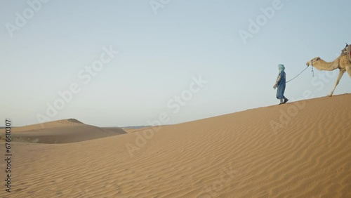 Berber man with 3 camels walking in the Sahara desert, Erg Chebbi, Morocco photo