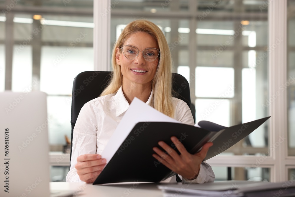 Smiling woman working at table in office. Lawyer, businesswoman, accountant or manager Smiling woman working at table in office. Lawyer, businesswoman, accountant or manager