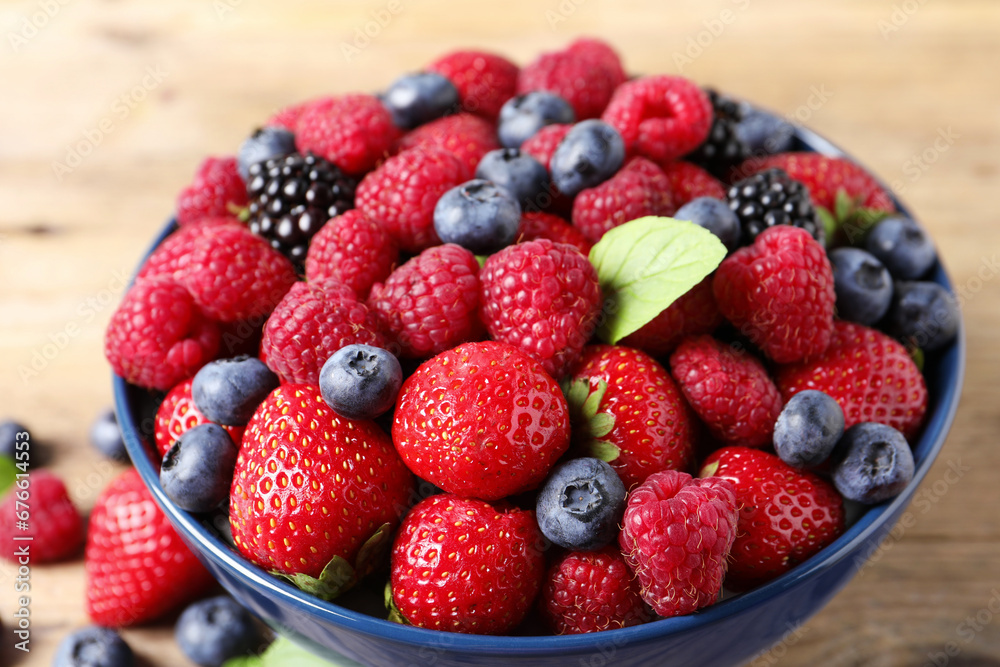 Different fresh ripe berries in bowl on table, closeup Different fresh ripe berries in bowl on table, closeup
