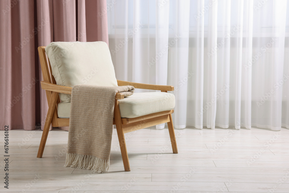 Comfortable armchair with blanket in room, space for text Comfortable armchair with blanket in room, space for text