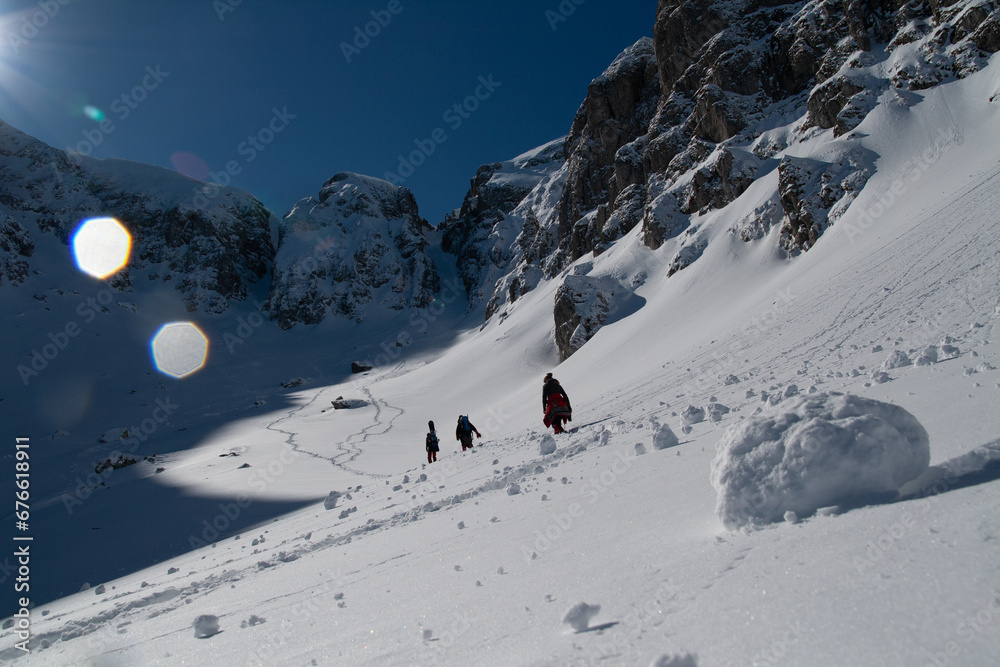 A team of determined climbers trudge uphill amidst the pristine white