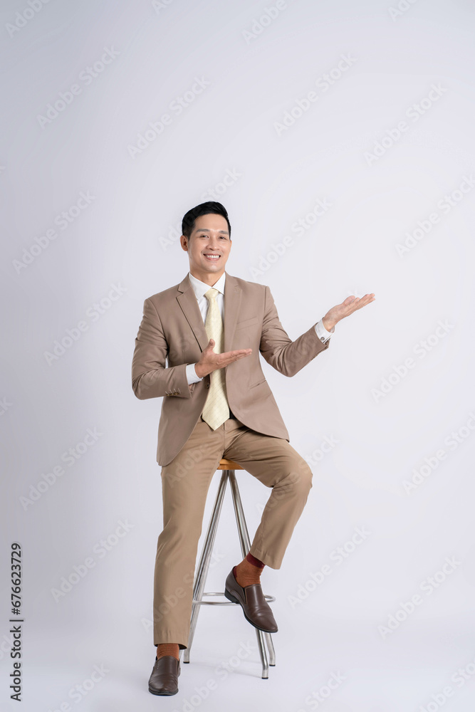 Portrait of a successful businessman siting and posing on a white background Portrait of a successful businessman siting and posing on a white background