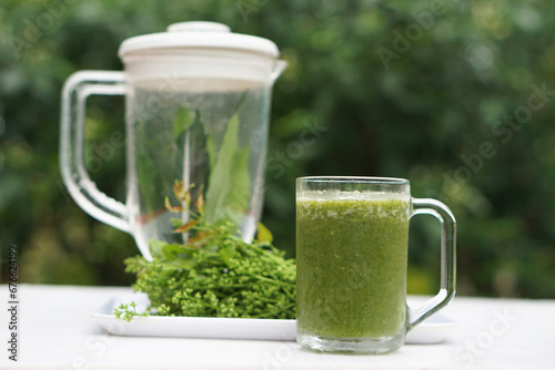 Green smoothie herbal vegetables in glass, outdoor background. Concept, healthy beverage for health. Well being and weight loss menu. Homemade refreshing drinks. High fibers, detox. 