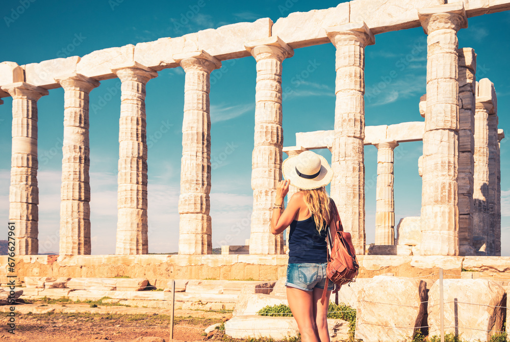 Female tourist with hat and bag visiting ancient ruins in Greece ( Temple of Poseidon)