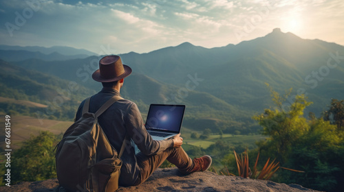 A freelance using laptop in nature with beautiful mountain view, concept of digital nomad working on the go concept. photo