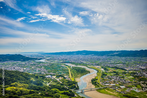 梅雨晴れの中、紀の川上空を飛ぶパラグライダーから和歌山市街と和歌山湾を撮影