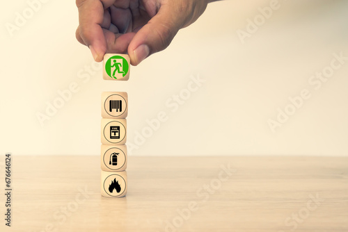 Fire prevention concept on cube wooden toy block stack with door exit sing or fire escape for prevent with fire extinguisher and emergency protection symbol for safety and rescue in the building.