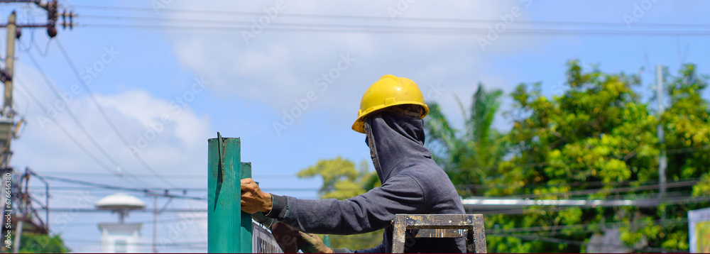 Fototapeta premium construction workers wearing safety helmets are working at height