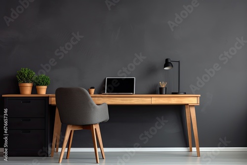 minimalistic home workplace with wooden desk and a dark grey wall