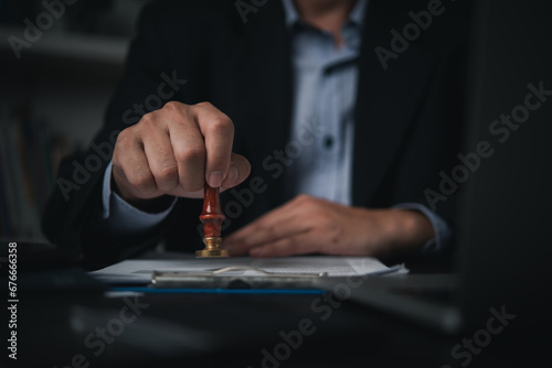Hand man stamping documents notary public in office . Businessperson stamping approval of work finance banking or investment marketing documents on desk..