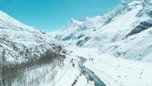Forward Drone shot over snow clad mountains and extreme terrain of Indian Himalayas. Scenic aerial view of mountain valley with Chandra river at Sissu, India. Winters in Himalayas. photo