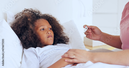 Sick, thermometer or a girl with a fever in bed to relax or recover and a parent in the home to care or check. Family, kids and an unhealthy female child in the bedroom of an apartment with a fever photo