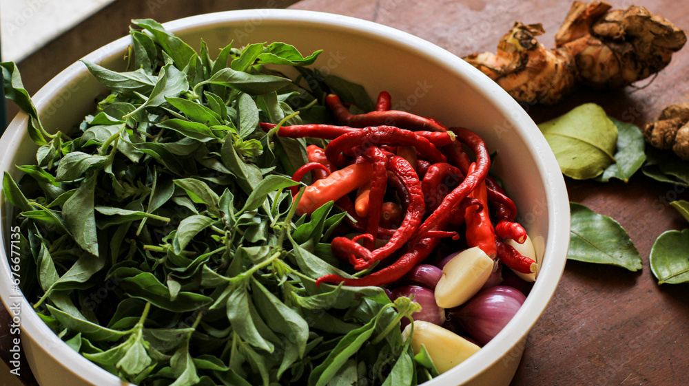 basil leaves, chilies and shallots in a container on the table basil leaves, chilies and shallots in a container on the table