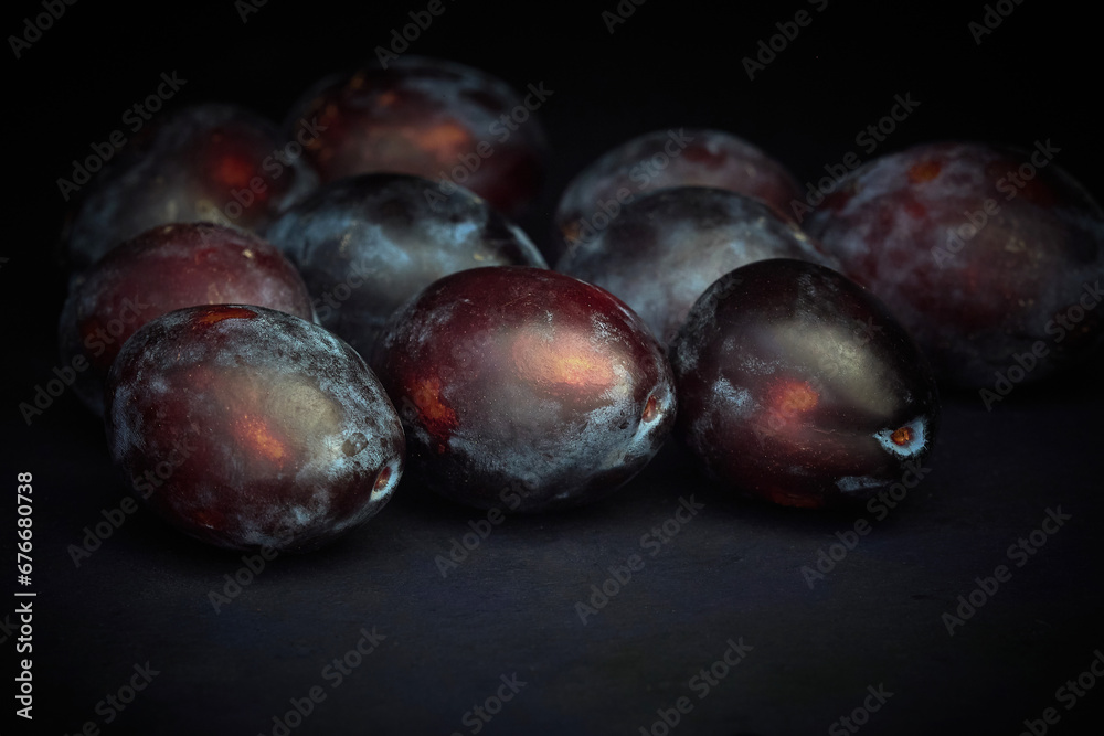 Obraz premium Ripe Prunes on a dark background