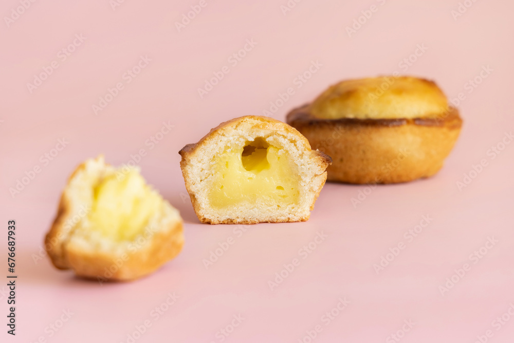 Pasticciotto leccese pastry filled with egg custard cream on a light pink, close up