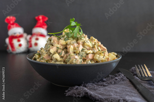 Traditional Russian Potato Salad Olivier for New Year's celebration on dark background.