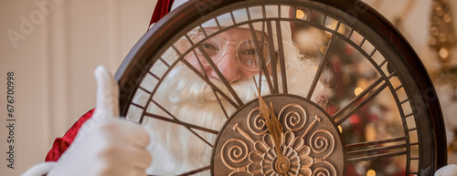 Five minutes to New year or Christmas midnight. Happy Santa Claus shows on the clock