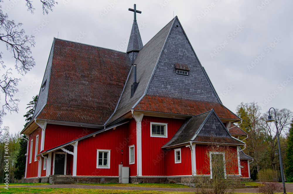 Red wooden church build in 1693. The church is located in the church village of Iiti, Finland. Church has a high and pointed Dutch hip roof, sometimes called a Dutch gable roof. Red wooden church build in 1693. The church is located in the church village of Iiti, Finland. Church has a high and pointed Dutch hip roof, sometimes called a Dutch gable roof.