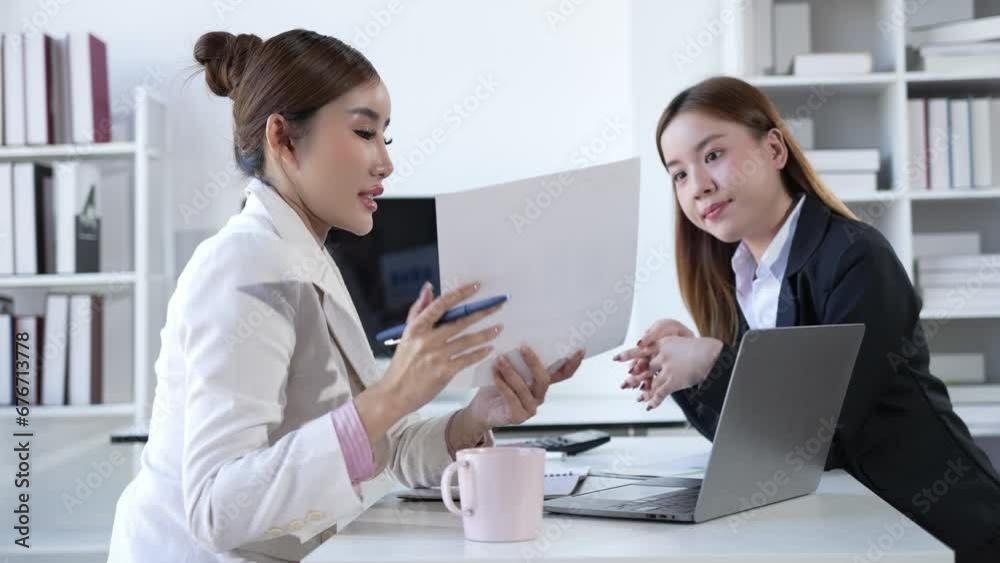 Two Asian businesswomen working on laptop computers discuss financial data in marketing project document analysis. 4k Two Asian businesswomen working on laptop computers discuss financial data in marketing project document analysis. 4k
