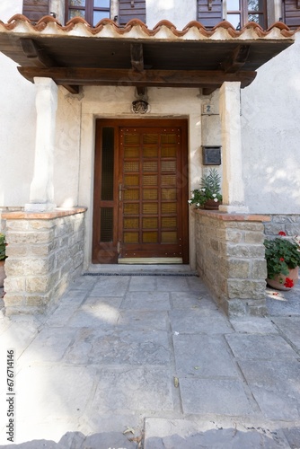 Image of a brown entrance door to a residential building with an antique fa  ade