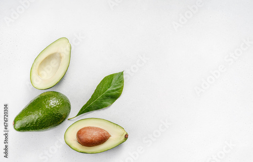 Avocado on white background. Halves of raw avocado fruit with avocado leaves. Top view of avocado.