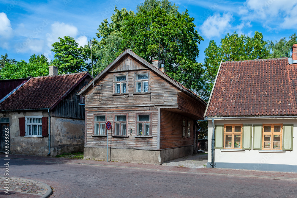 View of the street in Kuldiga with old wooden house and stone road. An example of wooden architecture from the 18th century. Latvia.