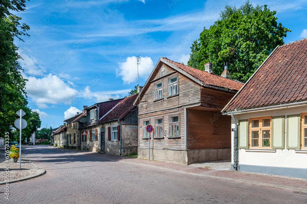 View of the street in Kuldiga with old wooden house and stone road. An example of wooden architecture from the 18th century. Latvia.
