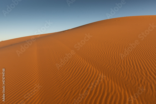 Sand ripples in contrasting colors with the sky in the Mezouga desert.
