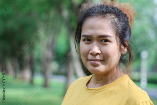 
Beautiful smiling Asian woman in the park green trees in spring nature background