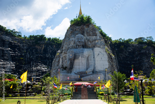 Sculpture carving big buddha carving on stone cliff mountain Wat Khao Tham Thiam for thai people travelers travel visit respect praying blessing and wish holy at U Thong city in Suphan Buri, Thailand photo