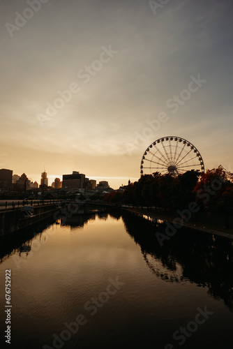 view of a ferris wheel and buildings near the canal at sunset in Montreal