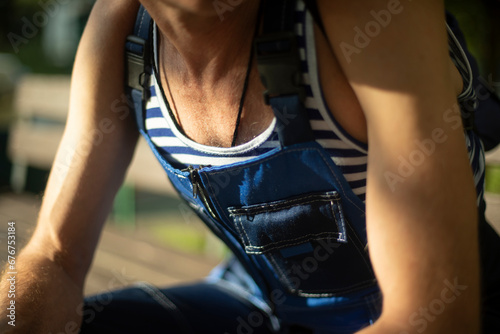 Man in nautical clothes. Sailor resting. Striped t-shirt. Overalls on the body.