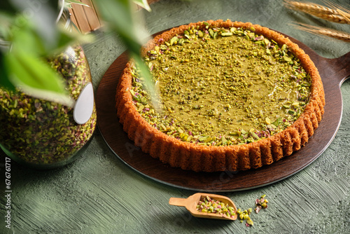 Pistachio cake with pistachios on a green background