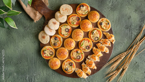 A plate of mini baked goods stuffed with cheese, meat, and mini pizza on a green field