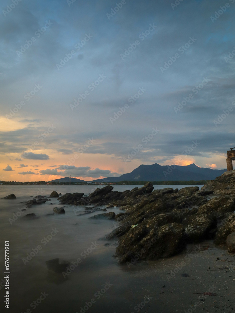 Fototapeta premium panoramic view of a rocky beach at sunset