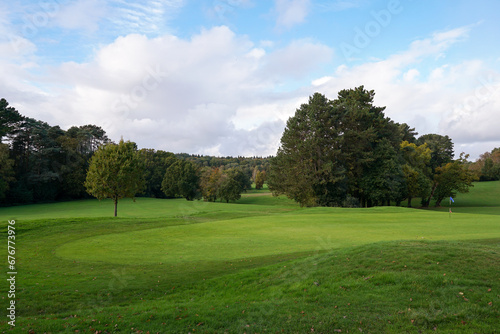 Golf course landscape. putting green surrounded by trees on golf course hole. Public sporting venue 
