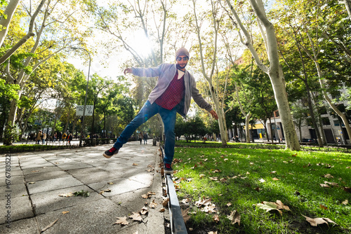 Street balancing act: Young man, wide-angle lens, showcases poise in autumn Madrid. © Rafael Alejandro