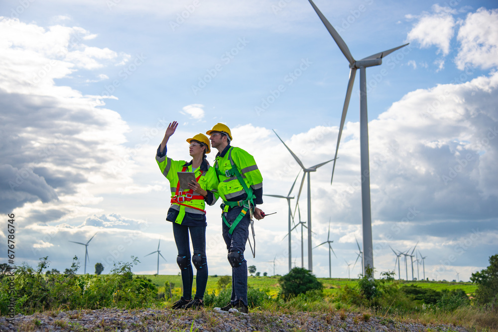 Two Engineers working in wind turbine farm , Sustainable energy industry concept, Renewable energy solution for climate change