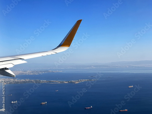 Aircraft wing high up in the blue sky over the Istanbul cargo harbor. Travel and transportation backgrounds