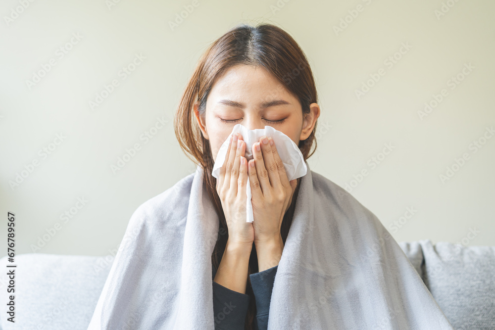 Sick, coronavirus or covid-19, attractive asian young woman, girl have a fever, flu and hand in use tissues paper sneezing nose, runny while sitting on sofa, couch at home. Health care on virus person Sick, coronavirus or covid-19, attractive asian young woman, girl have a fever, flu and hand in use tissues paper sneezing nose, runny while sitting on sofa, couch at home. Health care on virus person