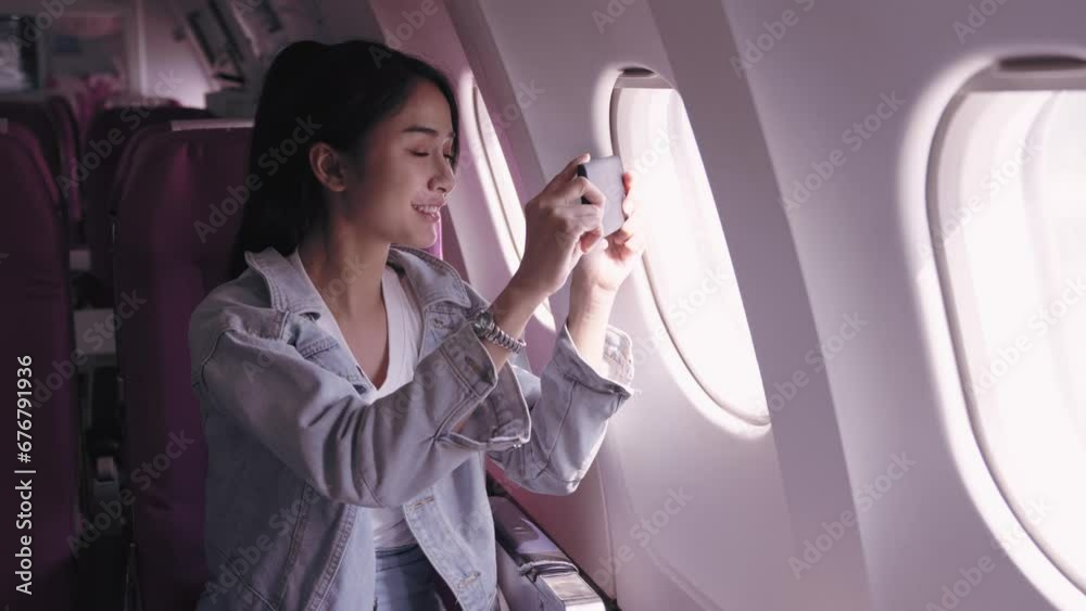Asian female tourists, currently on an airplane journey, are excitedly capturing pictures of the sky from the plane window, immersed in the beauty of the moment. capture the joy and beauty of travel.